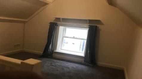 A small, cozy room with a window allowing natur...