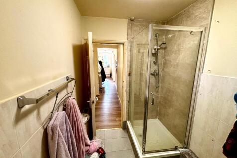 A functional bathroom featuring a shower with a...