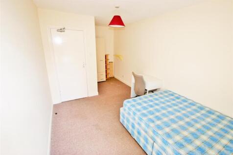 A spacious, bright bedroom featuring a comforta...