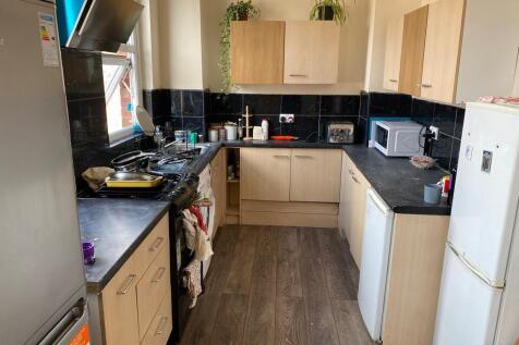 A functional kitchen with wooden cabinets, blac...