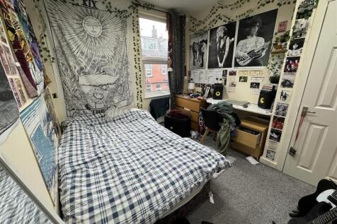 A cozy student bedroom featuring a double bed w...
