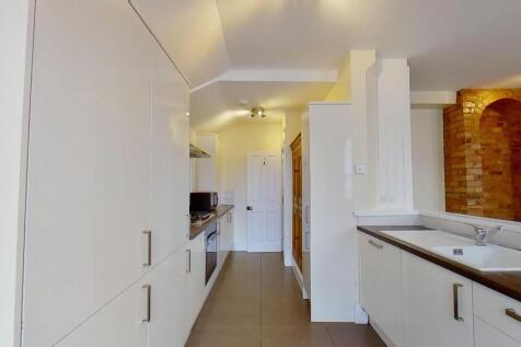 Modern galley kitchen with sleek white cabinetr...