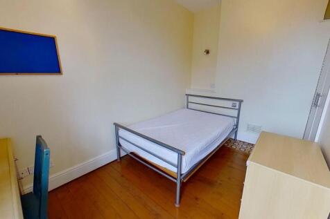 Neat single bedroom with a simple metal bedfram...