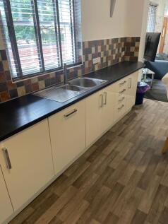Bright modern kitchen with a long black worktop...