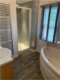 Bright modern bathroom with a corner bath, sepa...