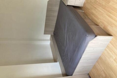 Neat, modern bedroom with a double bed set agai...