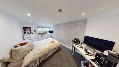 A spacious and well-lit master bedroom featurin...