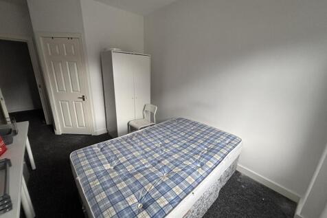 A cozy single bedroom with a simple bed in a br...