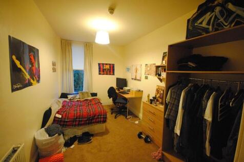 A well-lit bedroom featuring a single bed, a st...