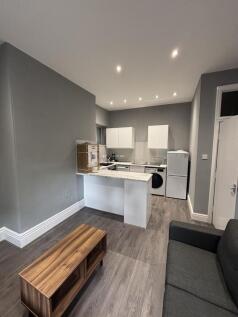 Modern kitchen area featuring bright cabinetry,...