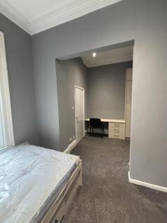 A cozy bedroom with neutral gray walls and a co...