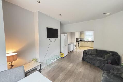 A modern, well-lit living room featuring a comf...