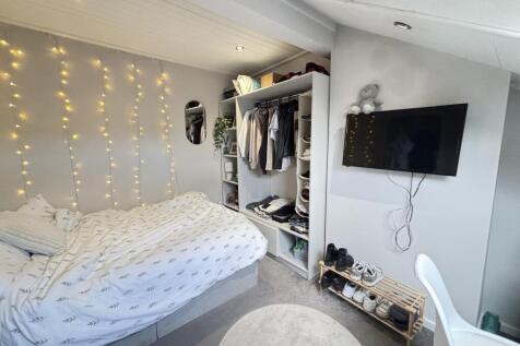 A bright and inviting bedroom featuring a comfo...