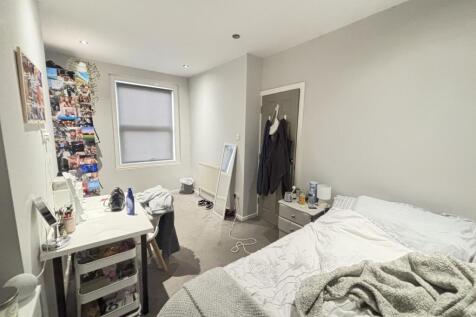 A bright and tidy bedroom featuring a comfortab...