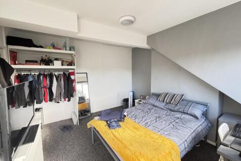 A well-lit, tidy bedroom featuring a double bed...