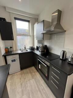 A modern, well-maintained kitchen with sleek bl...