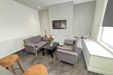 A modern, well-lit living room featuring comfor...