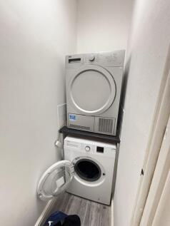 A modern bathroom featuring a clean, stacked wa...