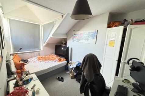 A cozy bedroom featuring a double bed, a study ...