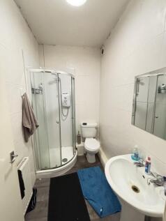 A functional bathroom with a shower unit, toile...