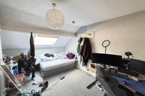 A spacious master bedroom featuring a large bed...