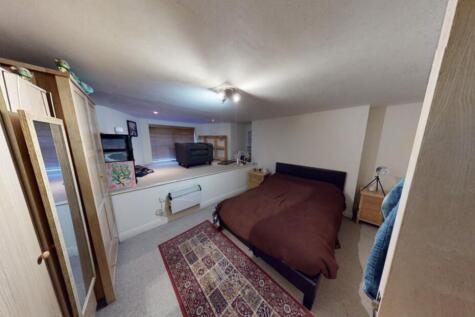 A cozy bedroom featuring a double bed with a da...