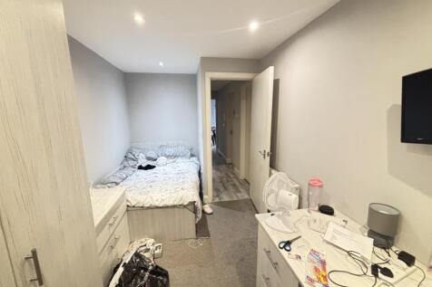 A bright bedroom with a double bed positioned a...