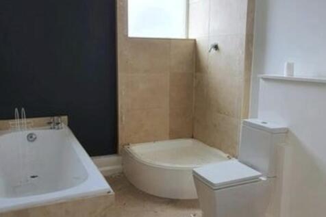 A clean and modern bathroom featuring a bathtub...