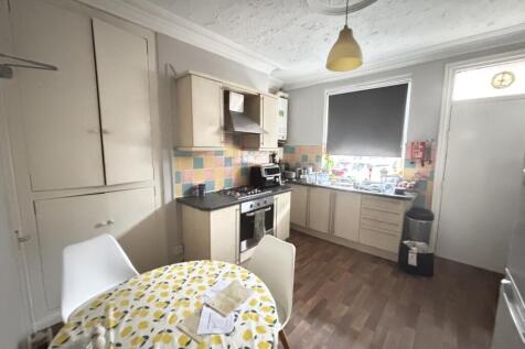 A compact kitchen area with a small dining tabl...