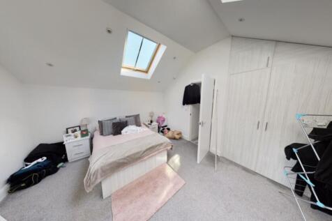 A bright and airy bedroom with a cozy bed, ampl...