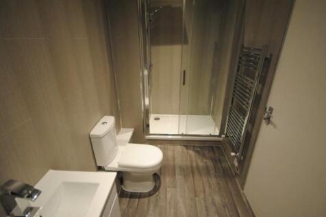 A modern, clean bathroom featuring a toilet, wi...