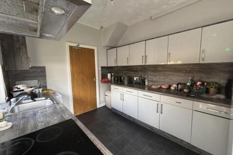 A well-organized kitchen with ample white cabin...