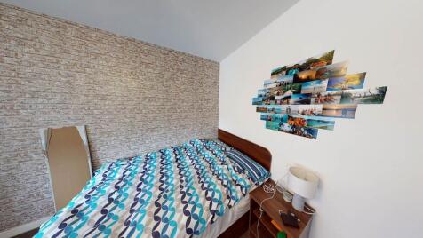 A cozy bedroom featuring a double bed with a co...