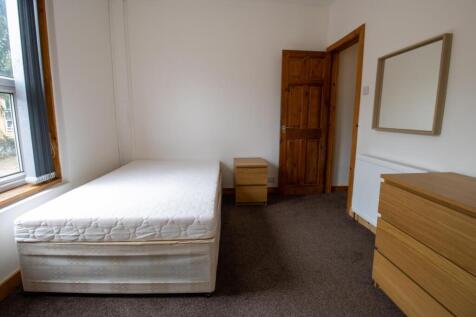 Bright, simply furnished bedroom with a comfort...