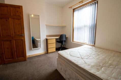 Bright, simply furnished bedroom with a double ...
