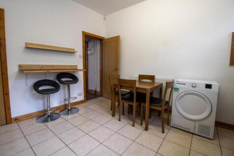 Bright tiled kitchen/dining area with a small d...