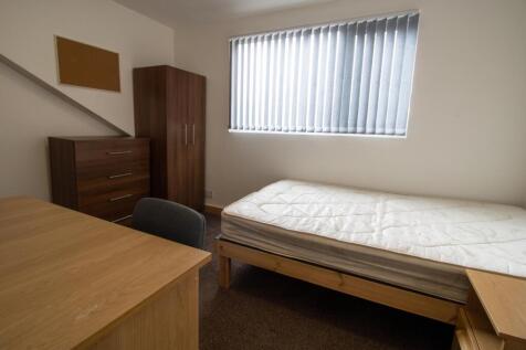 Neat furnished bedroom with a single bed, desk ...