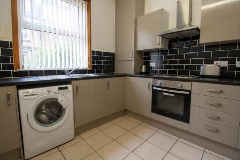 Modern galley-style kitchen with neutral cabine...