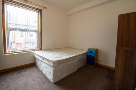 Bright, simply furnished bedroom with a double ...