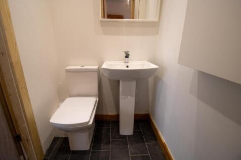 Neat, modern bathroom with a pedestal sink, clo...