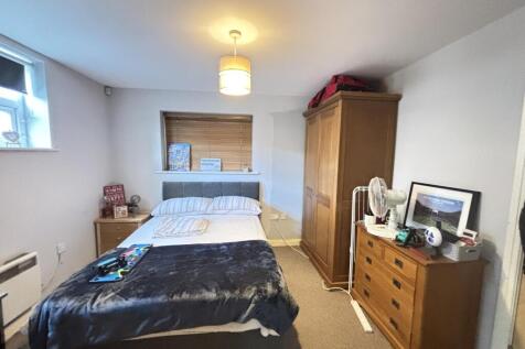 A spacious and well-kept bedroom featuring a la...