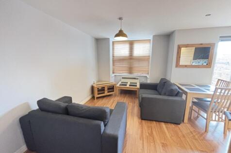 Bright and spacious living room with two comfor...