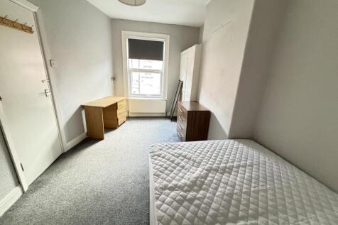 A bright and tidy single bedroom with a comfort...