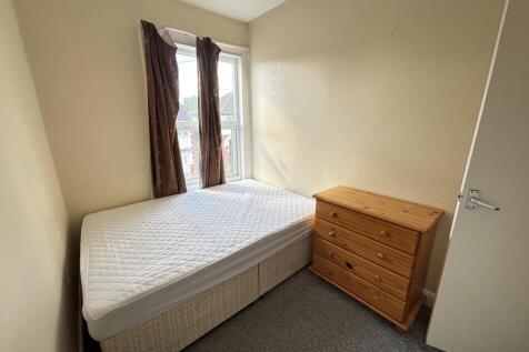 A small, tidy room featuring a single toilet wi...