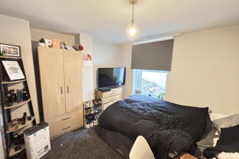 A cozy bedroom featuring a large bed positioned...