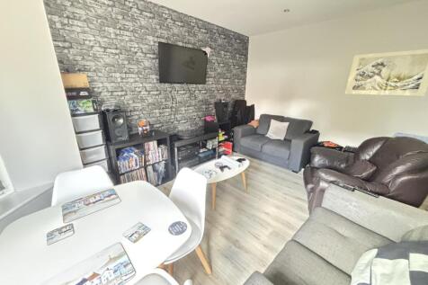 A spacious and modern living room featuring com...