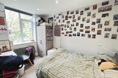 A cozy single bedroom featuring a bed and perso...