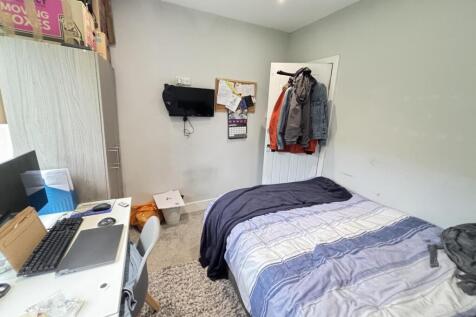 A cozy bedroom featuring a double bed, personal...