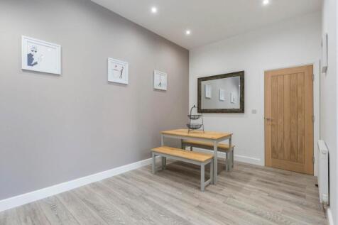 Bright, modern communal lounge with light wood ...