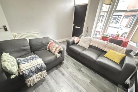 A bright, modern living room featuring two comf...